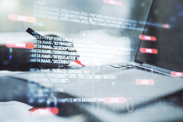 Abstract creative coding concept with hand writing in notebook on background with laptop. Multiexposure