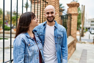 Fototapeta premium Young hispanic couple smiling happy standing at the city.
