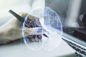 Creative artificial Intelligence concept with human brain hologram and hand writing in notebook on...