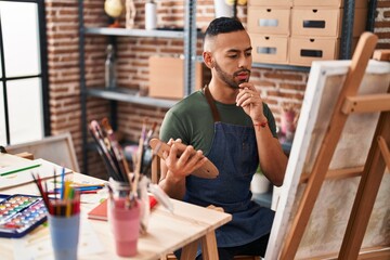 African american man artist drawing with doubt expression at art studio