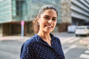 Young latin woman smiling confident standing at street