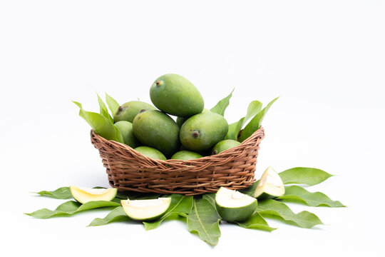 Fresh Green Raw Mango Also Called Aam, Kairi In Tradition Indian Wooden Basket Has Multiple Health Benefits, Is Rich Source Of Vitamins. Used For Chutney, Khatta Aam Panna And Aam Ka Achar Pickle