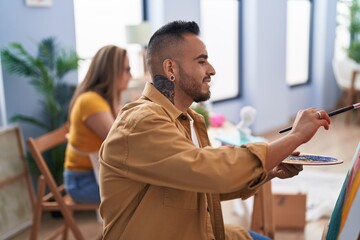Man and woman artists smiling confident drawing at art studio