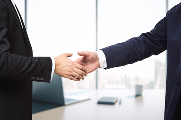 Two businessmen shake hands in sunny modern office, deal concept, close up