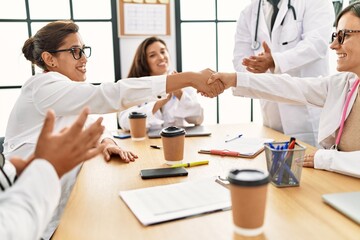 Fototapeta premium Group of doctor clapping to partners handshake in a medical meeting at the clinic office.
