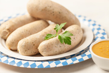 Munich white sausage with sweet mustard on paper plate.