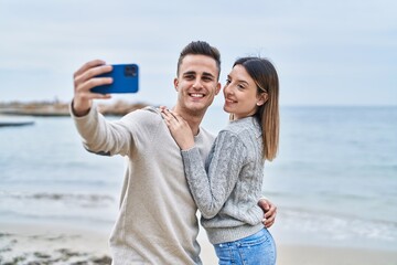 Man and woman couple hugging each other make selfie by smartphone at seaside