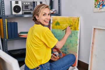Fototapeta na wymiar Young blonde woman artist smiling confident drawing at art studio