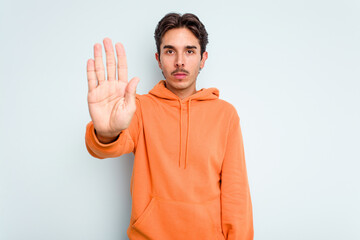 Young hispanic man isolated on blue background standing with outstretched hand showing stop sign,...