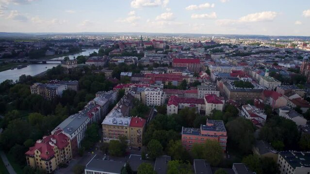 Krakow city skyline in old town near Wisla river at sunrise in summer, Poland  - Slow aerial push-back dolly 