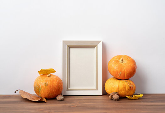 Art photo frame mockup with scarfs and autumn leaves, white background