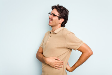 Obraz premium Young hispanic man isolated on blue background suffering a back pain.