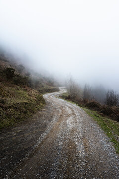 Camino sinuoso en la montaña con niebla al fondo