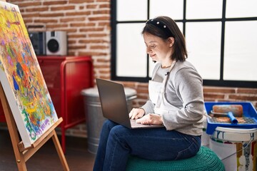 Young woman with down syndrome artist using laptop drawing at art studio