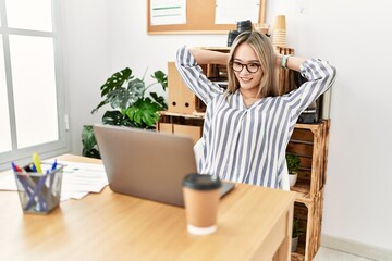 Young chinese woman smiling confident relaxed with hands on head at office