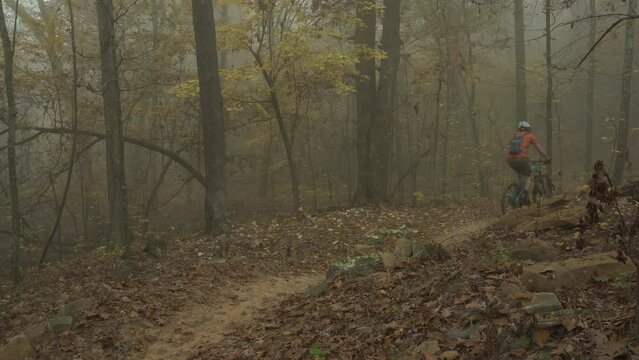 Mountain biker biking through Mt. Nebo Arkansas bike trial path on the fall forest  