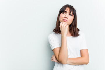 Young caucasian woman isolated on white background looking sideways with doubtful and skeptical expression.