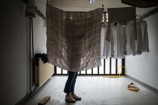 Copenhagen, Denmark A Person Hangs Laundry In A Communal Laundry Room In An Apartment Building.