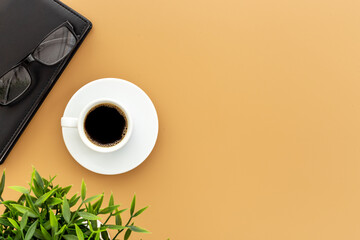 White cup of hot black coffee with glasses and notepad. Coffee break time concept