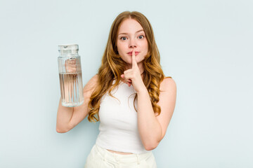 Young caucasian woman holding jar of water isolated on blue background keeping a secret or asking for silence.