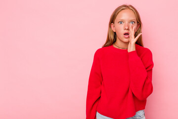 Caucasian teen girl isolated on pink background is saying a secret hot braking news and looking...
