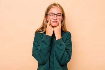 Caucasian teen girl isolated on beige background crying, unhappy with something, agony and confusion concept.