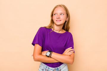 Caucasian teen girl isolated on beige background dreaming of achieving goals and purposes