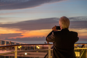 Man taking a sunset picture on a cruise