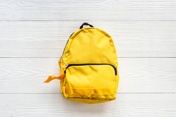 Classic yellow school backpack top view. Educational objects background