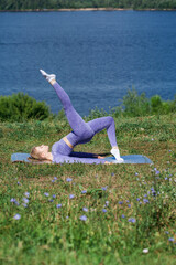 Young woman in sports uniform is engaged in fitness outdoors