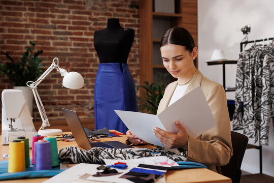 Portrait of a young girl of a fashion designer against the background of a maniken and a sewing machine.
