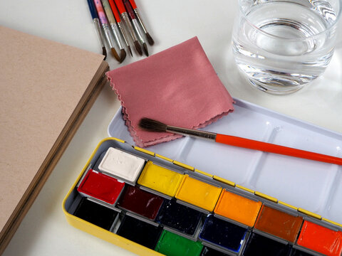 A box of watercolors, paint brushes