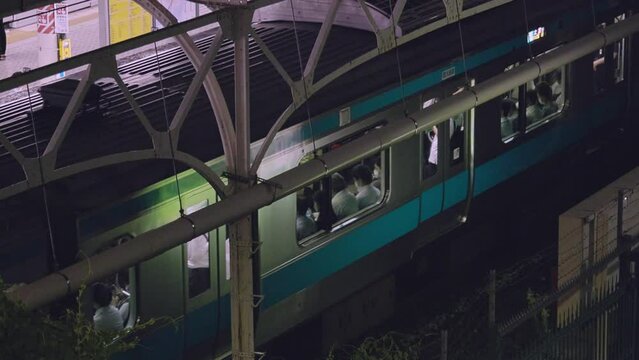 夜、電車で帰宅する人々の風景