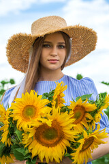 Young beautiful girl with a bouquet of sunflowers