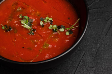Soup, tomato soup on a black background side view