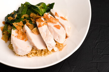 Chicken with bulgur, hot dish with chicken and bulgur on a black background side view