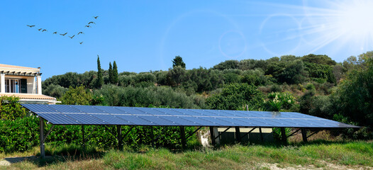Fototapeta premium Solar batteries in the green home garden. Green energy concept. Solar energy