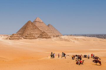 Fototapeta na wymiar Cairo, Egypt. 08.25.2022. Group of tourists watching the Panoramic view of the pyramids of Micerino, Kefren and Cheops.