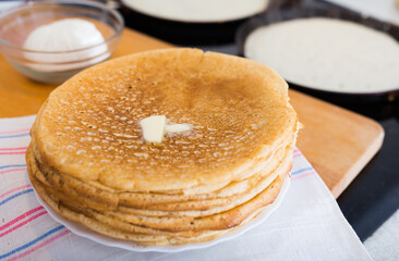 freshly baked hot cereal pancakes on plate and pans during cooking