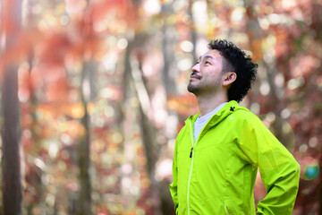 森や公園で運動したり、リラックスする男性　アップ　秋冬