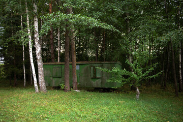 Abandoned trailer in woods. View of an abandoned caravan in a forest with trees. Vintage retro...
