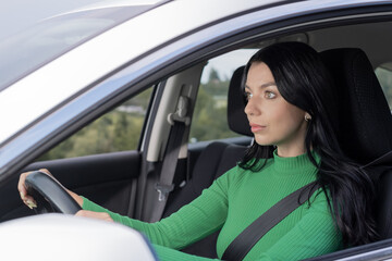 A serious young woman drive in her car. driver steering car with safety belt. Car Transportation concept.