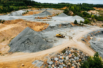 Aerial view of Truck excavator in open sand quarry rubble in Finland.