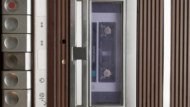 Closeup shot of hands holding vintage recod tape into old player
