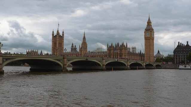 Houses of Parliament and the City of Westminster Bridge, Big Ben, Castle, Abbey and Thames River in London, England in 2022 with birds flying. Cloud sky as Queen Elizabeth died and Charles is King. 4K
