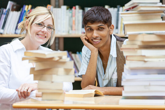 Teenage Students: School of Knowledge. A teacher helping her students in the college library. From a series of high school education related images.