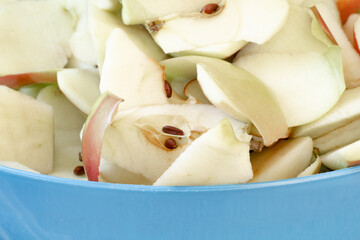 Sliced apples and peelings in blue bowl ready for composting