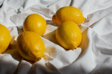 fresh yellow lemons in sunlight  on bed on bed. hard light