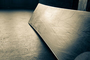 a scratched snowboard close-up lying on the floor at a ski base waiting for its rider, the front...