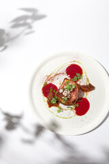 Baked camembert in parma ham on brioche with berry jam. Elegant food - hot appetizer of camembert and ham in summer menu. Cheese appetizer in fine dining. Summer menu.